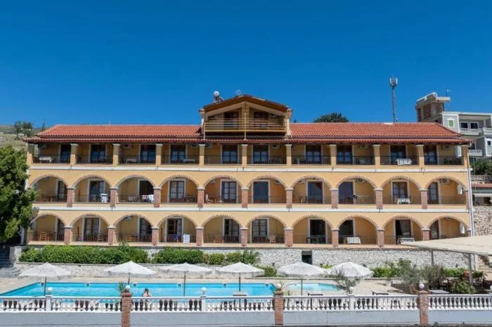 The front of Apart Hotel Alex: a ten-arch front, two arcaded tiers under a third storey on square piers, a red pantile roof and a timber penthouse on the ridge