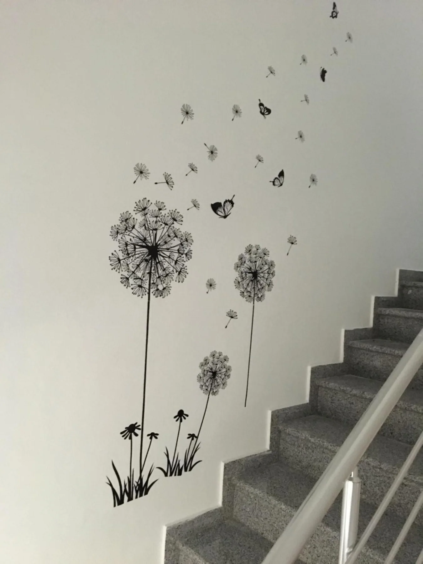 The building's stairwell, granite treads with a white handrail and a dandelion drawn on the wall