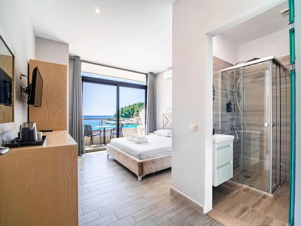 A double room with its own shower room in the foreground and a sea-facing balcony beyond