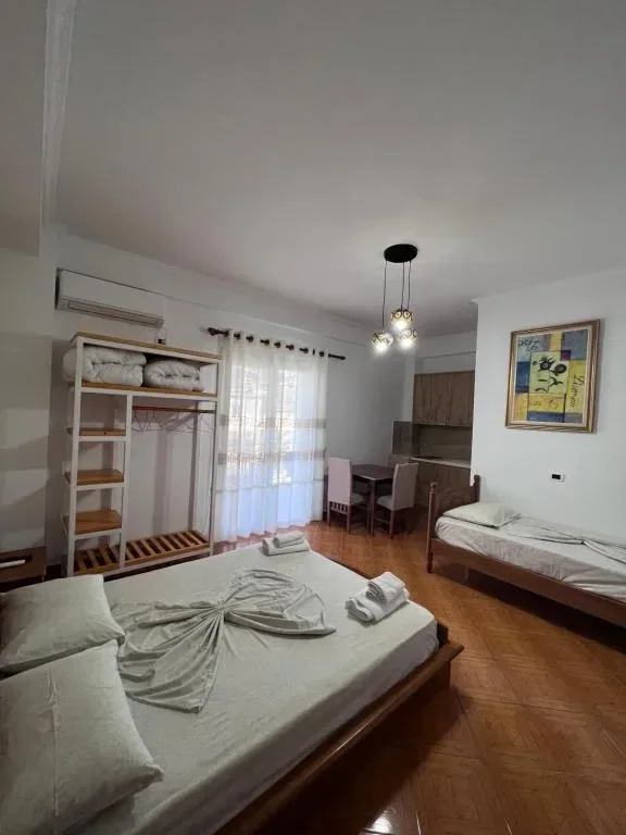 Triple Room: the bed, a second single bed, the open shelf unit and the dining table