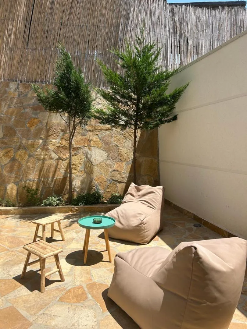 A walled flagstone courtyard with beanbag seating and young cypresses
