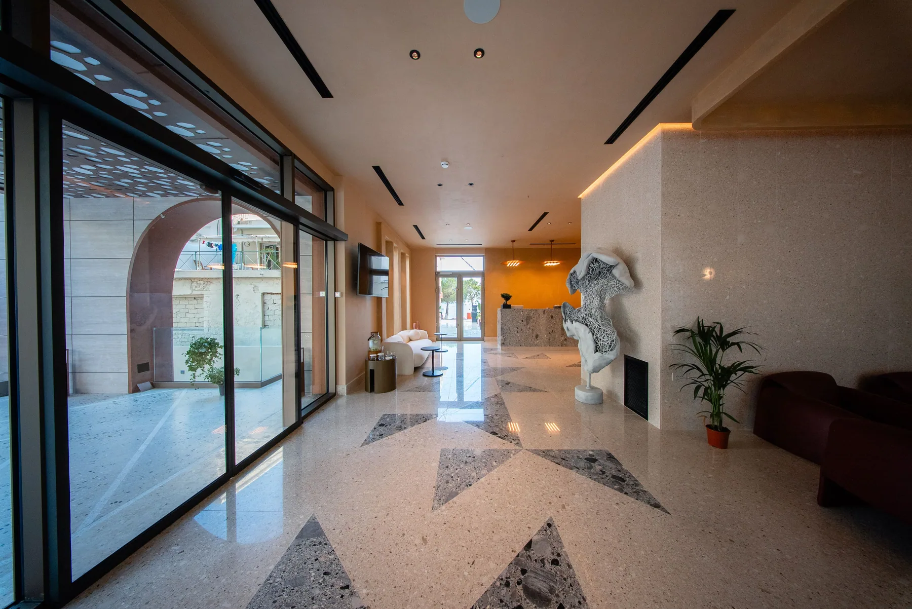 The glazed entrance and terrazzo lobby of Saint Nicolas Hotel