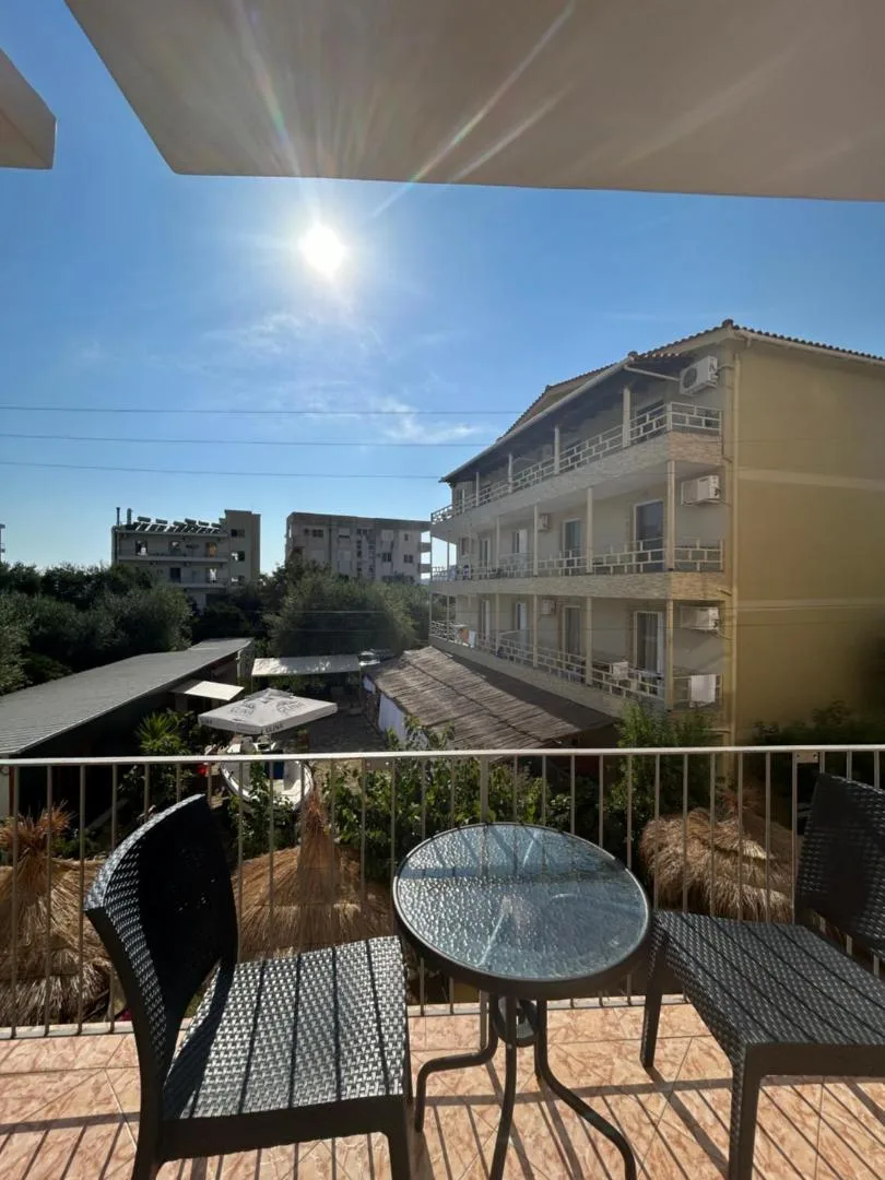 Balcony at Areti Rooms Hotel with two chairs and a table looking across to the neighbouring block