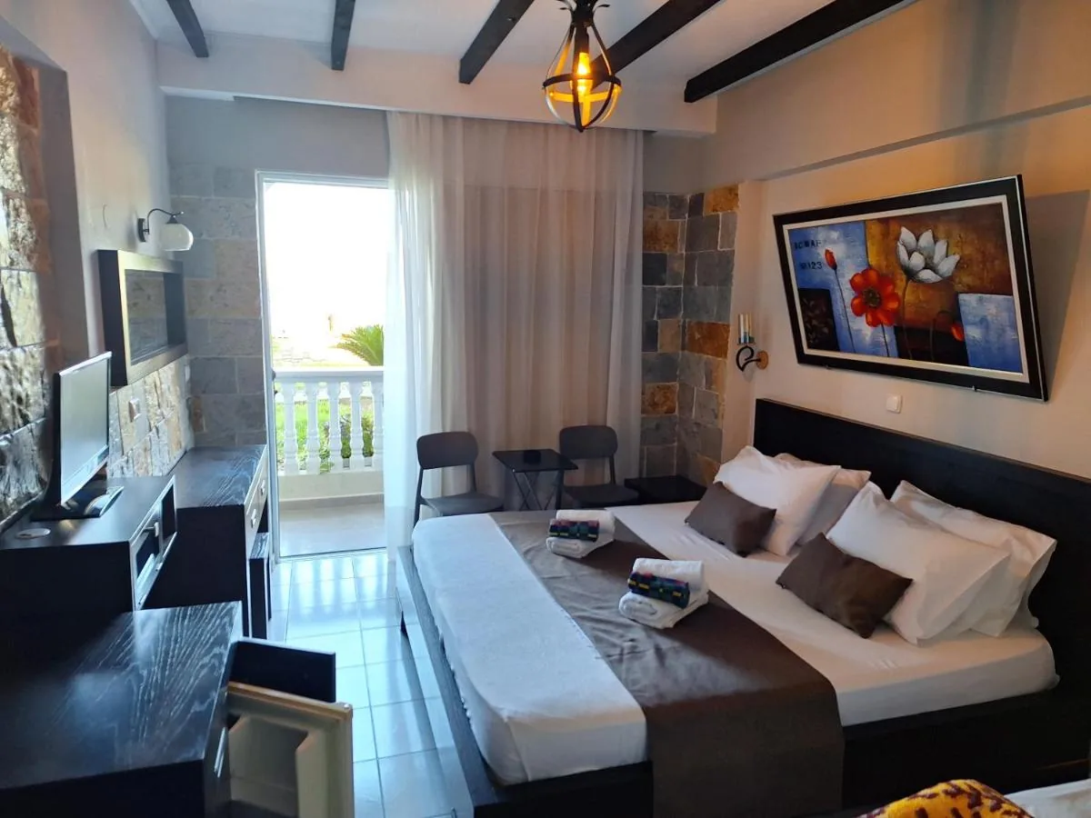 A guest room at Castle Hotel with exposed dark beams, a wrought-iron lantern, split-face stone on the walls and a balcony behind sheer curtains