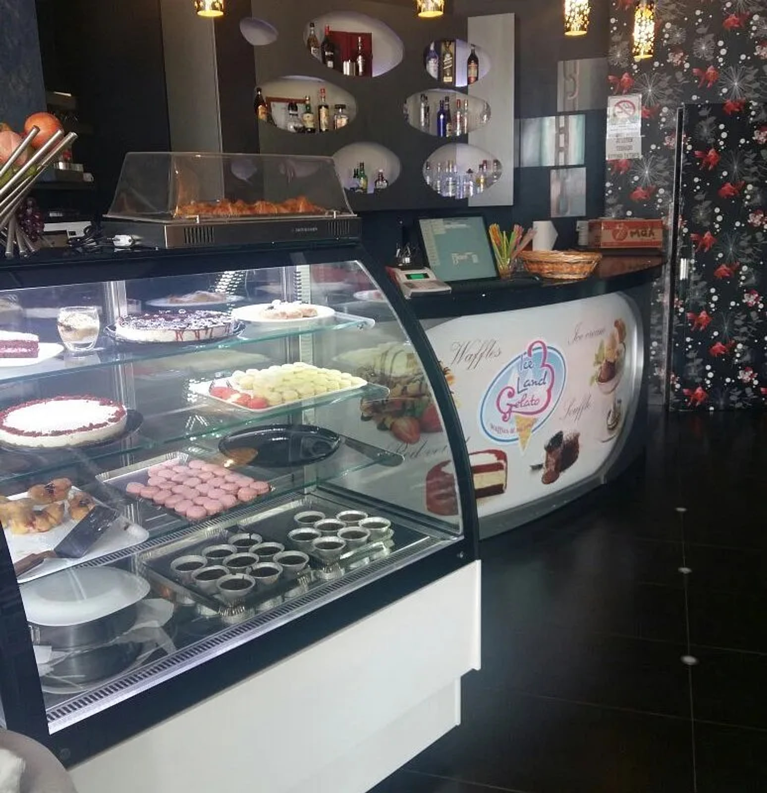 The service counter inside, its curved front printed with the Ice Land Gelato mark and the words Waffles and Ice cream