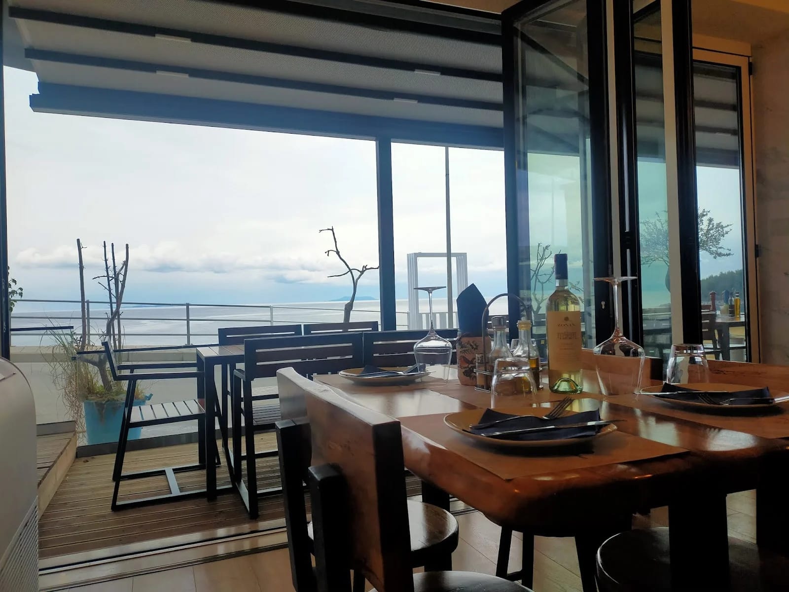 The restaurant's folding glass front opened onto a timber deck, with the bay and headland beyond