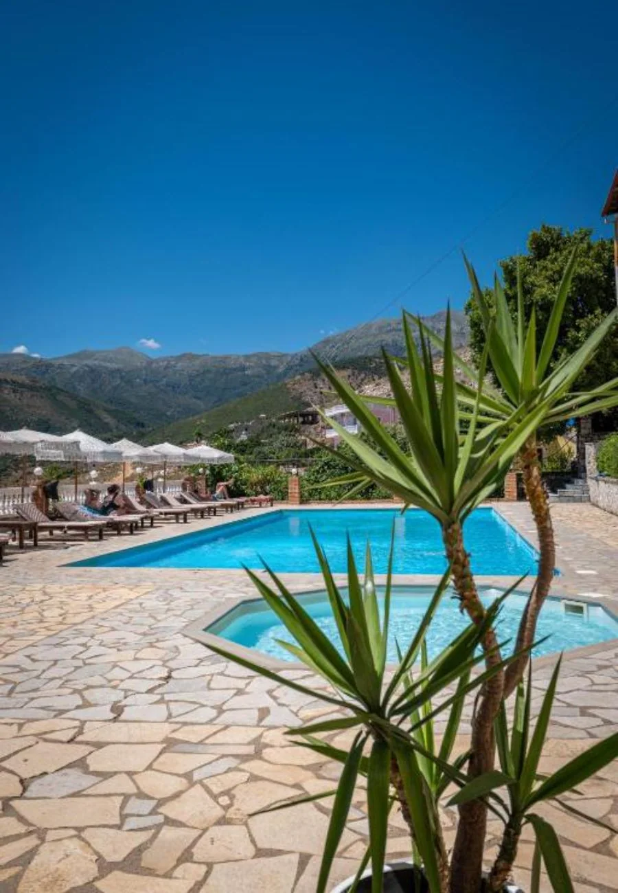 The children's pool in the foreground with a yucca beside it, the long pool behind and the mountains across the valley