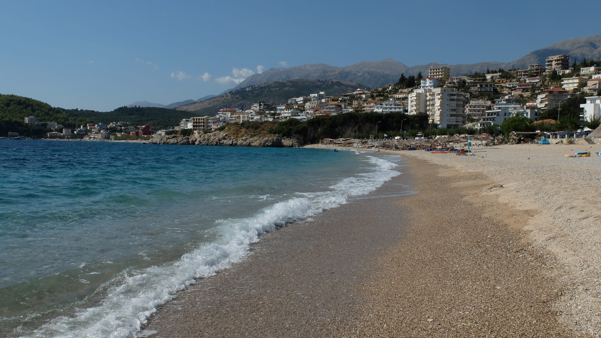 Spile beach at the waterline, the town and mountains rising behind it