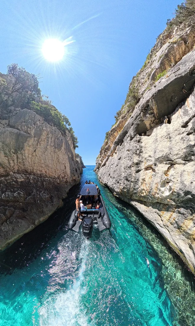 Narrow turquoise water channel between high cliff walls at Smuggler's Canyon on the Karaburun Peninsula