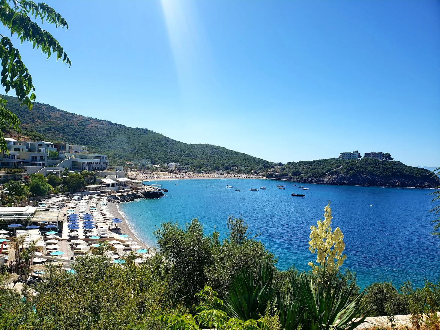 Folie Marine beach club at Jale with rows of umbrellas and sun loungers along the bay and turquoise Ionian water