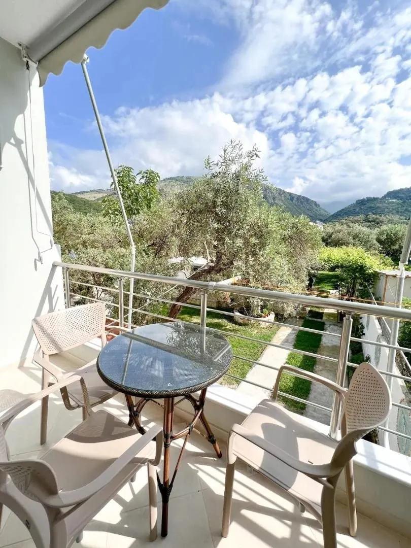 A balcony overlooking the lawn and olive trees behind the building