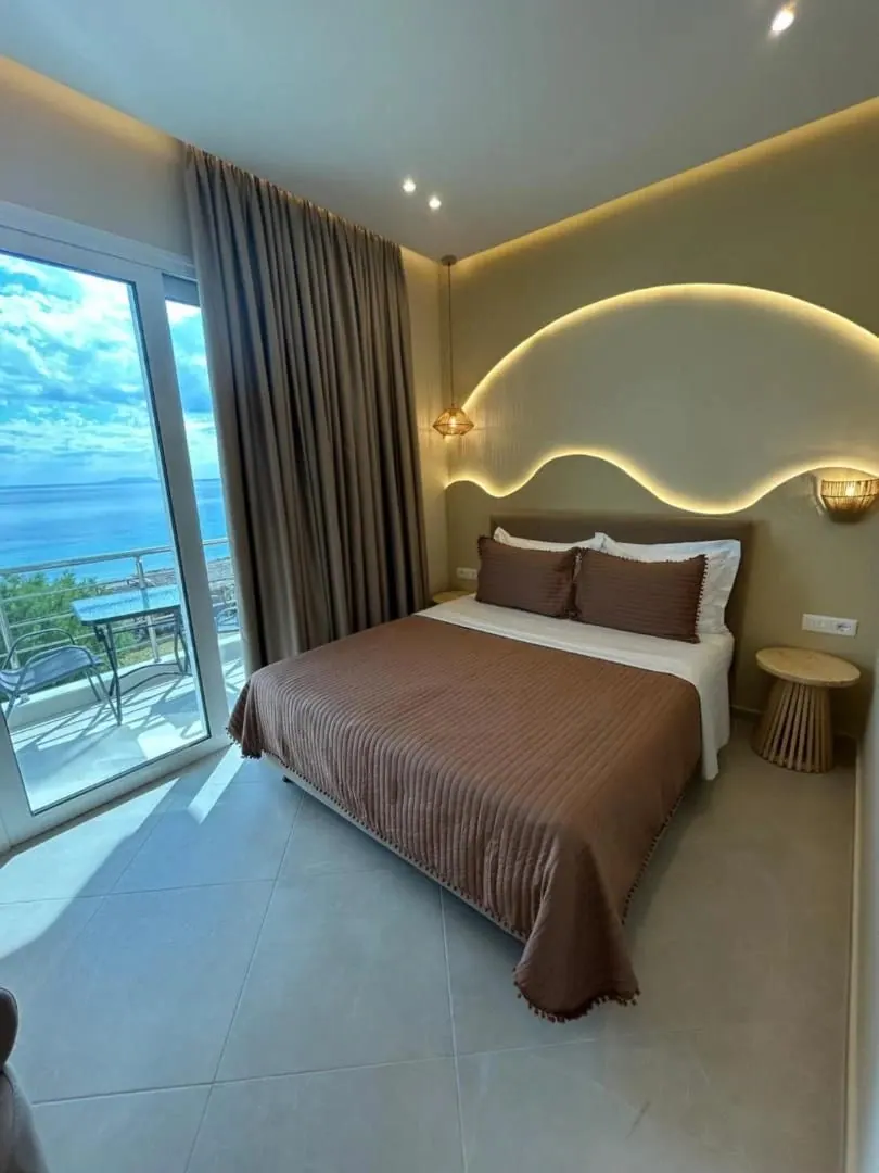 A sea-facing room, an arc of cove lighting above the bed and the water through the balcony glazing