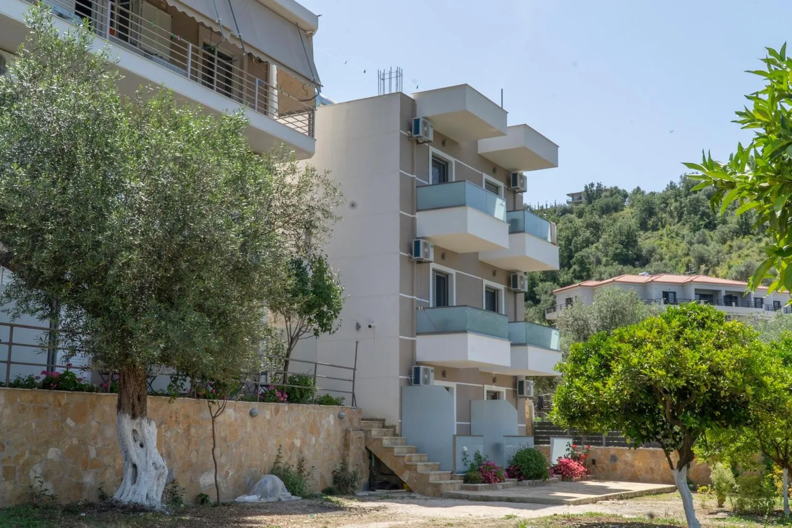 The rear block of the guesthouse with stacked balconies and an outside stair
