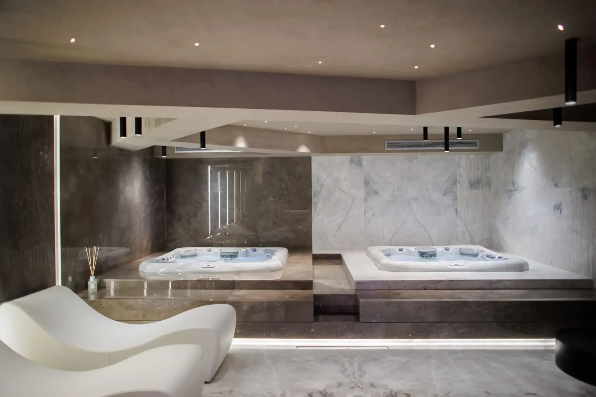 Moulded white loungers and a jacuzzi on its marble plinth in the spa at Prado