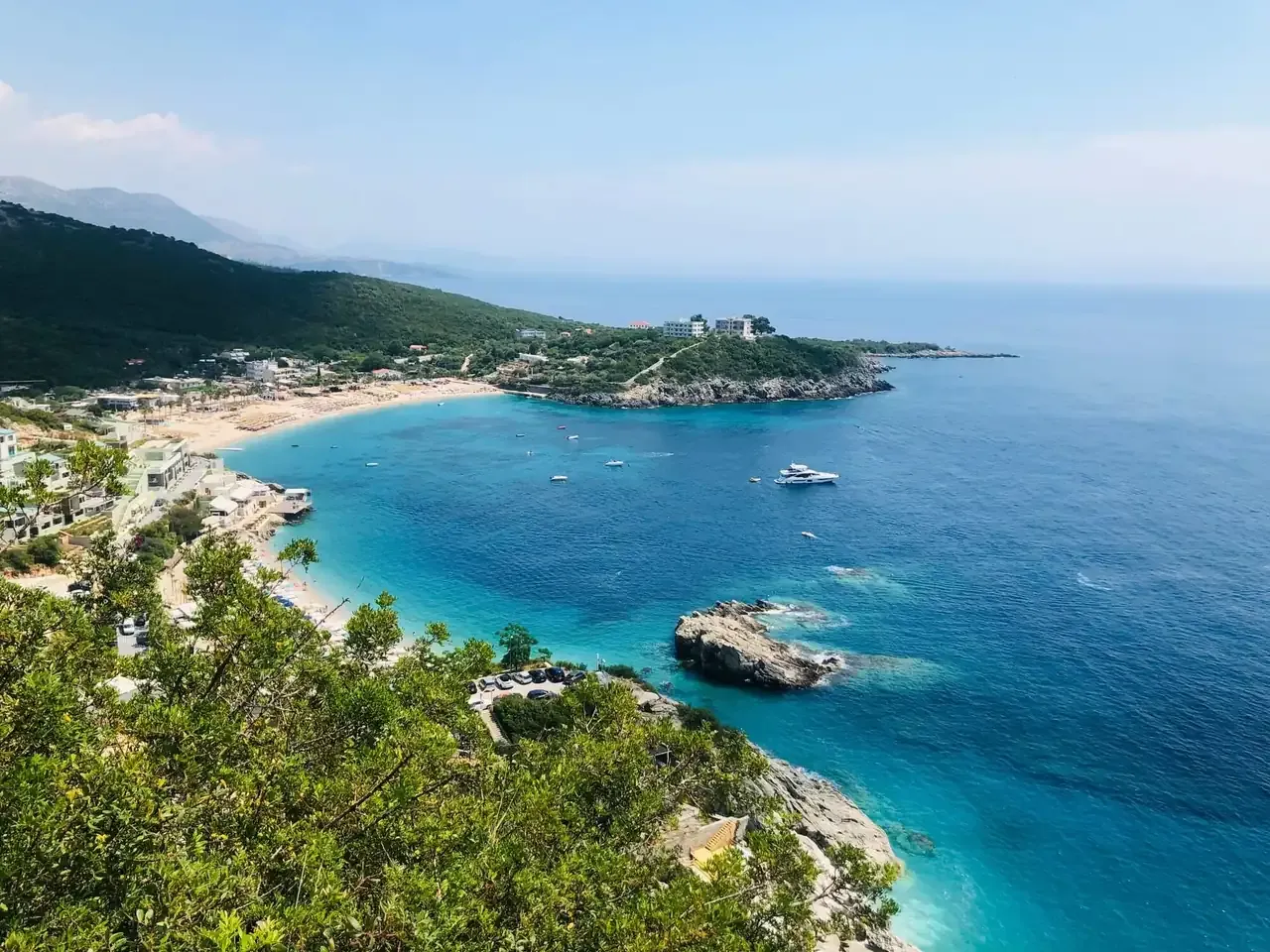 Jale bay from the road above, its pale beach and turquoise water below green hillsides