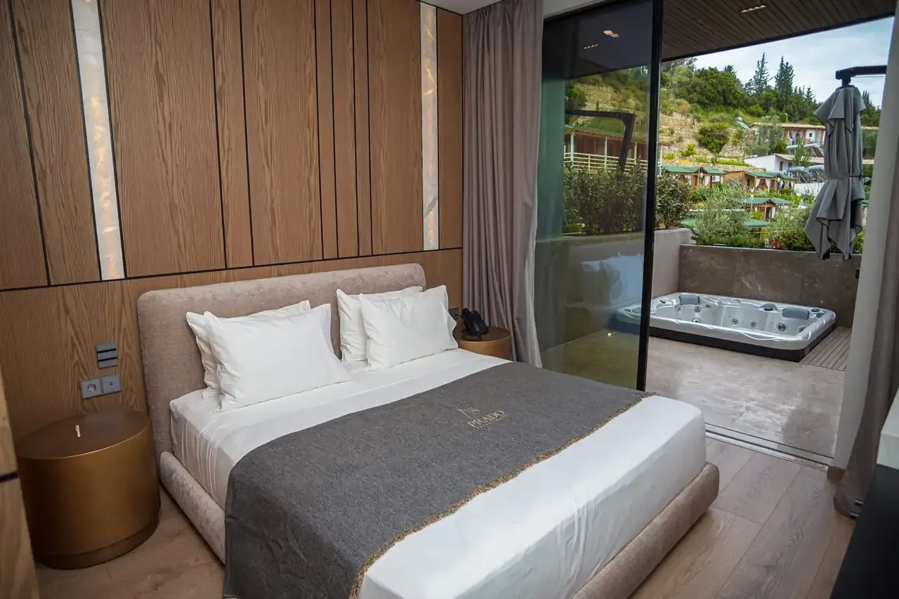A jacuzzi on the balcony of a Standard Room, seen from the bed, with the hills beyond