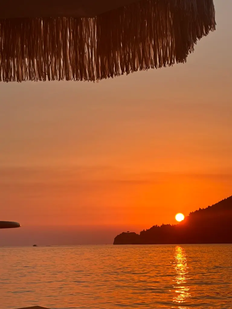 Ocean horizon with orange winter sunset sky near Himara