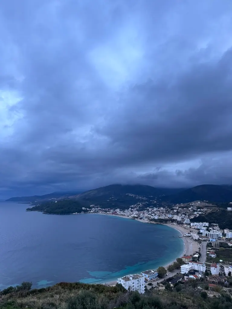Panoramic aerial view of Himara's Spile Bay with turquoise water and mountains