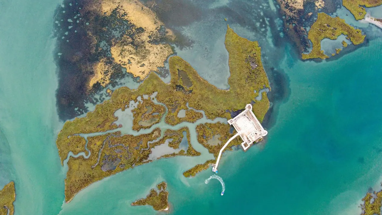 Aerial of a fortified ruin on a marshy lagoon island in the Butrint area near Ksamil — a key day-trip site on a Saranda-Ksamil split stay
