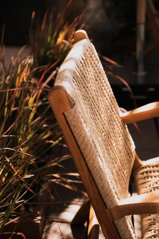A rattan chair among grasses on the roof deck