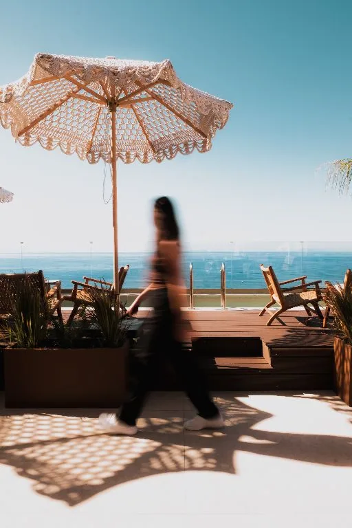 The roof deck at noon, parasol shadows across the boards