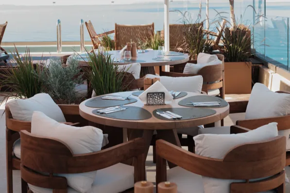 Round tables and cushioned chairs on the roof in the morning