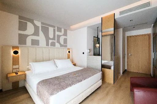 The bed in a Double Room with Sea View, under the sculpted relief panel