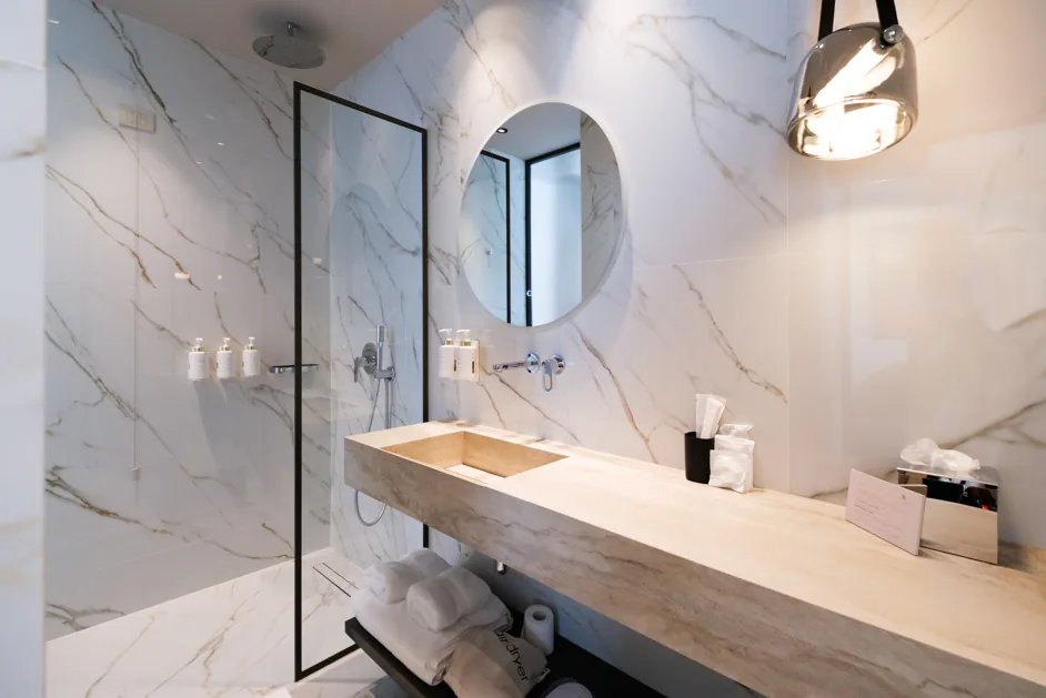 The Junior Suite bathroom, marble with a walk-in shower and no bath