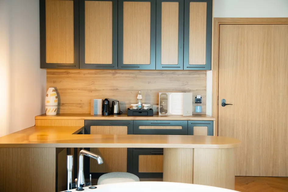 The kitchenette in Suite 305, grey-green joinery with oak panels