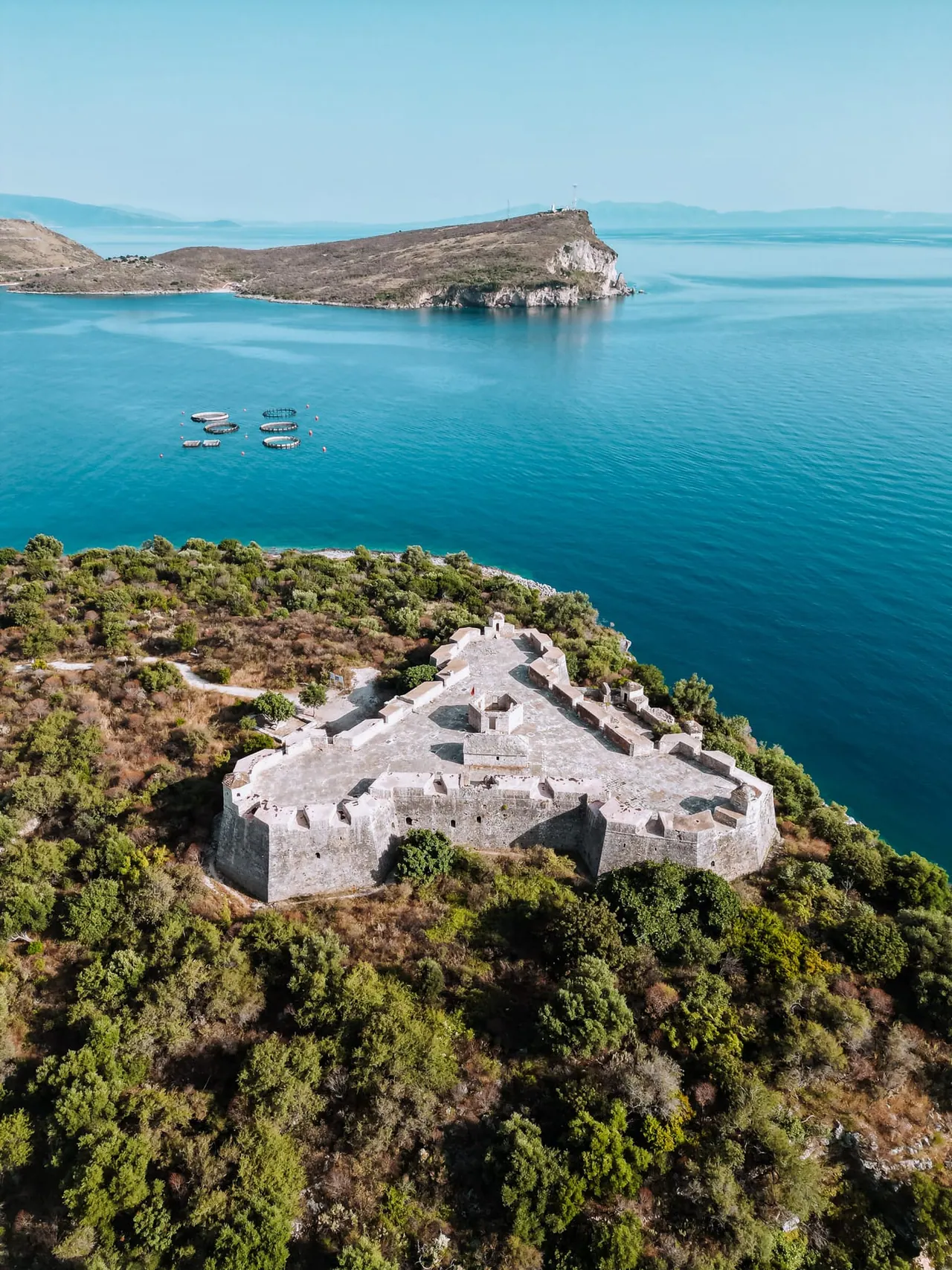 The triangular stone fortress at Porto Palermo on its causeway in the bay