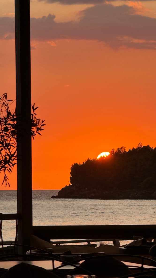 The sun going down behind the wooded headland at the south end of Potam Beach, Himarë