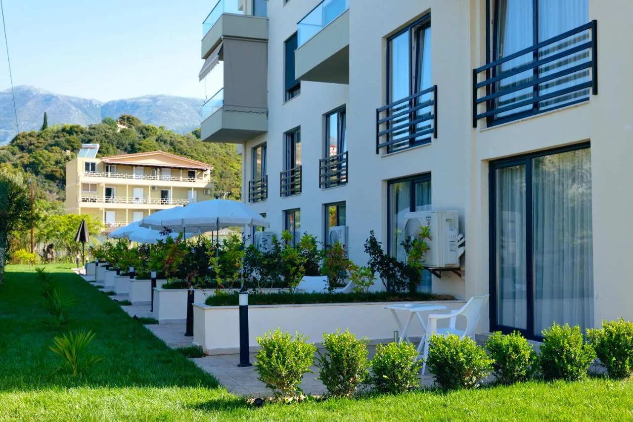 The garden elevation of the hotel in morning light, with balconies, a parasol and the hills behind
