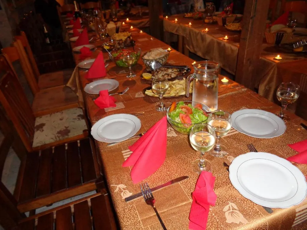 Long tables laid with candles and dishes in Taverna Velco on the ground floor